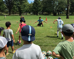 画像　障害者アスリートが子どもたちにサッカーを指導する様子の写真