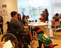 介助犬を連れた車いす利用者がワークショップに参加している場面の写真
