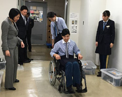 車いすに実際に座り、操作や支援方法を確認する社員の写真