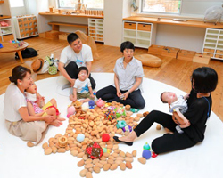 在宅の難病児、障害児と家族のための「スマイルデー」の様子。参加者がおもちゃを囲んで語り合う場面