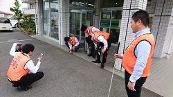 画像　従業員が街のバリアフリー状況を調査し、情報をアプリに投稿している場面の写真