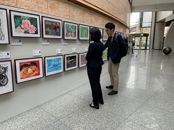 画像　通行人が展示された障害者アートを鑑賞している場面の写真