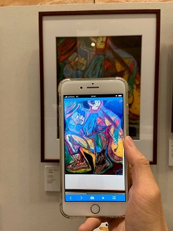 画像　スマートフォンを作品にかざしてARコンテンツを体験している場面の写真