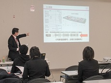 画像　講師がパワーポイントを用いて従業員に説明している場面の写真