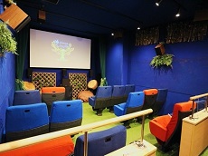 画像　青い壁に森の中をイメージして植物を配置したシアター館内の写真