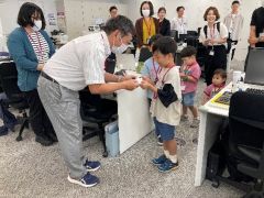 画像　職場参観日で、自作の名刺を社員と交換する体験の模様