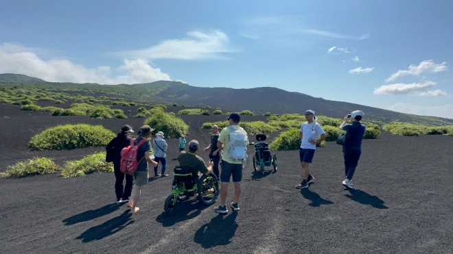 画像　日本で唯一の砂漠をアウトドア車イスで観光支援している様子